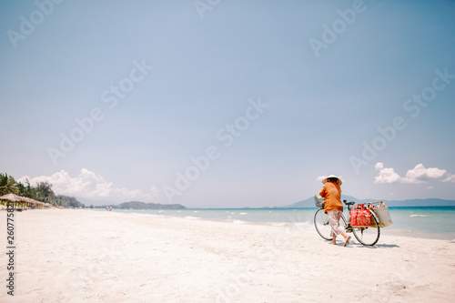 Beach seller in a hat with a bicycle