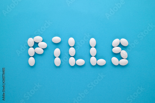 Pills on blue background. Word composed out of pills