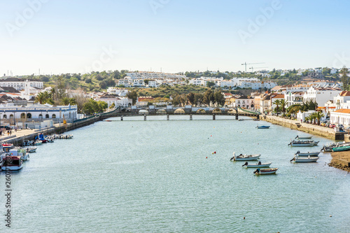 Cityscape fo Tavira with fisherman boats and roman bridge over Gilao river, Portugal