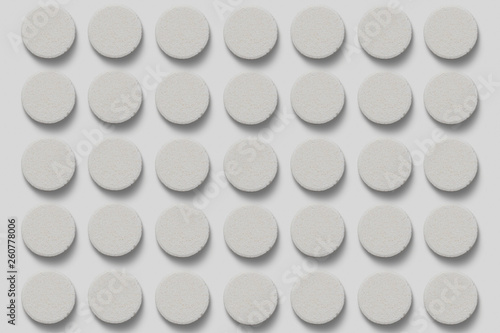 Stack of supplement effervescent tablets pattern texture. Multivitamin supplement tablet. Soluble Vitamin. Fizzy tablets isolated on soft gray background.