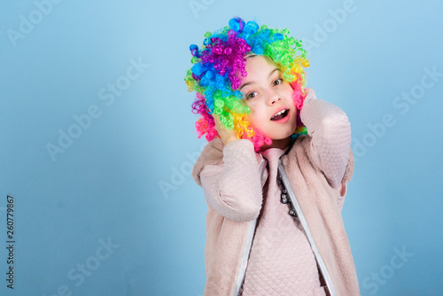 Kid colorful curly wig artificial hair clown style blue background. Circus school concept. Acting school for children. Develop acting talent into career. Girl artistic kid practicing acting skills