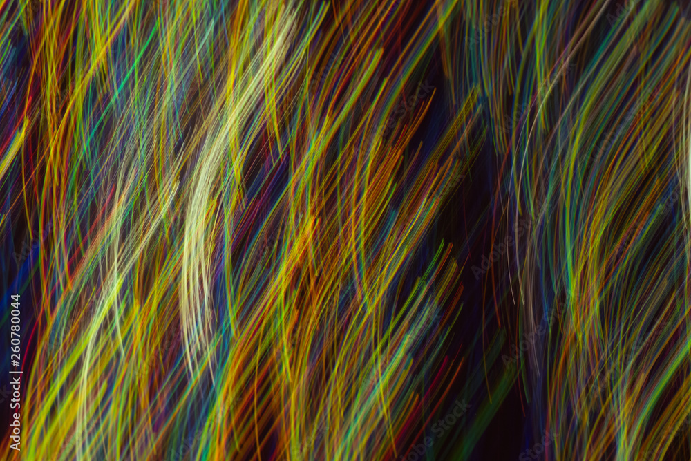 Defocused lights in motion. Blurred vertical multicolor lines on dark background. Lens flare effect.