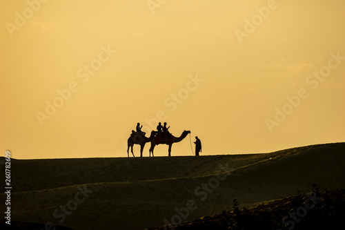 Sam Sand Dunes  Jaisalmer  Rajasthan  India  24-Feb-2019  camel ride silhouette against orange sky