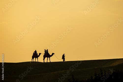 Sam Sand Dunes  Jaisalmer  Rajasthan  India  24-Feb-2019  camel ride silhouette against orange sky