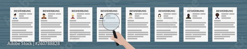 Hand mit Lupe sieht Bewerbungen an