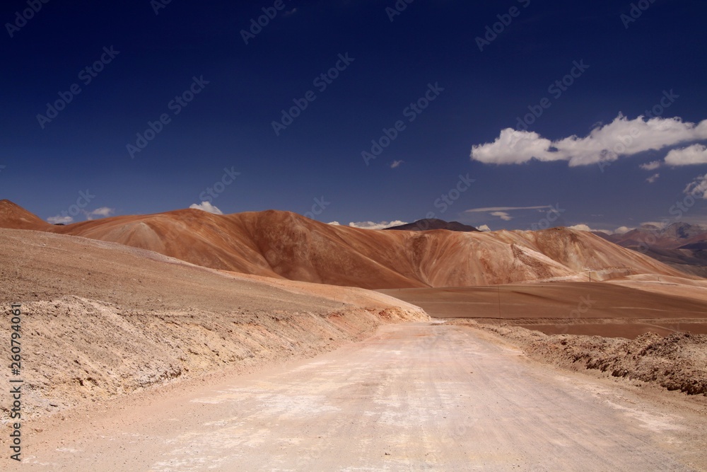 Empty dirt road to colorful Copiapo mountains in Atacama desert, Chile