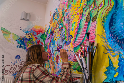 Young female artist doodling on the wall, bright psychedelic mind flow deep relaxation painting © Alexander Zvarich 