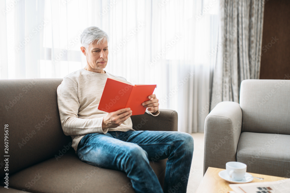 Adult man with notebook sitting on couch at home
