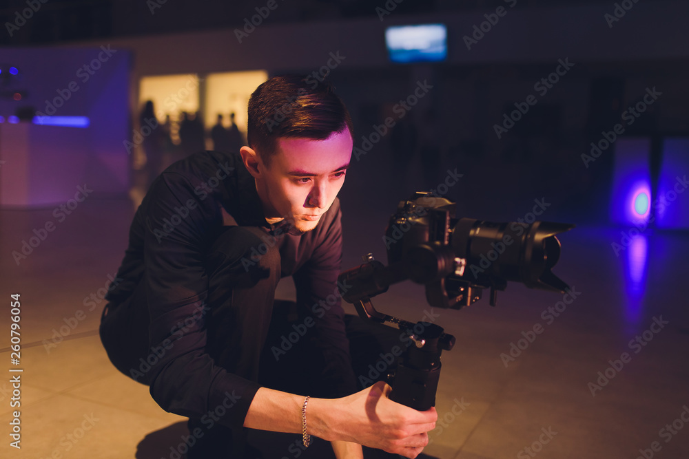 Εκτύπωση καμβά Professional videographer holding camera on 3-axis gimbal