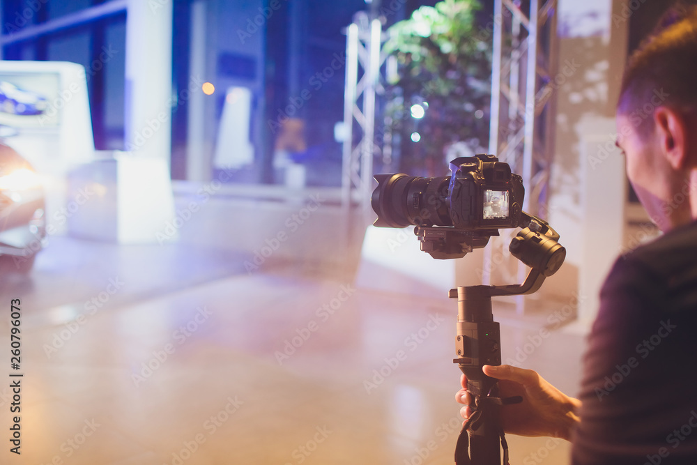 Fotografie Professional videographer holding camera on 3-axis gimbal