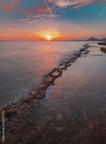 View of a sunset in a mediterranean cove with the last rays of the sun in the seascape
