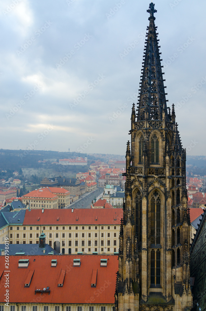 Gothic stone tower of St. Vitus Cathedral on background of city, Prague, Czech Republic
