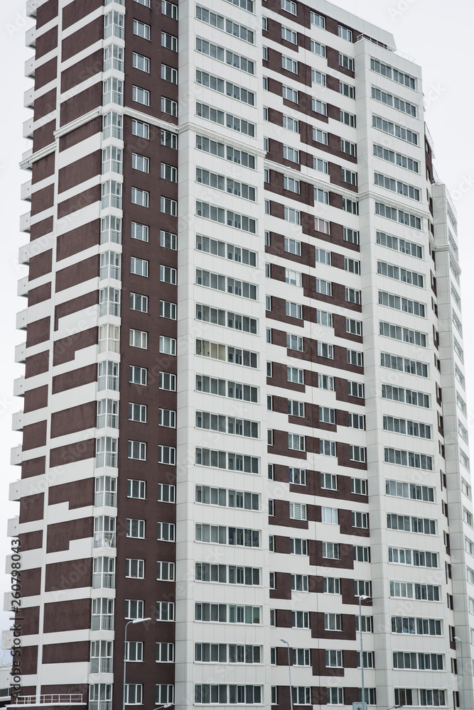 Sleeping urban area. Multi-storey residential building with white and brown facade. Sleeping urban area. Multi-storey residential building with white and brown facade.