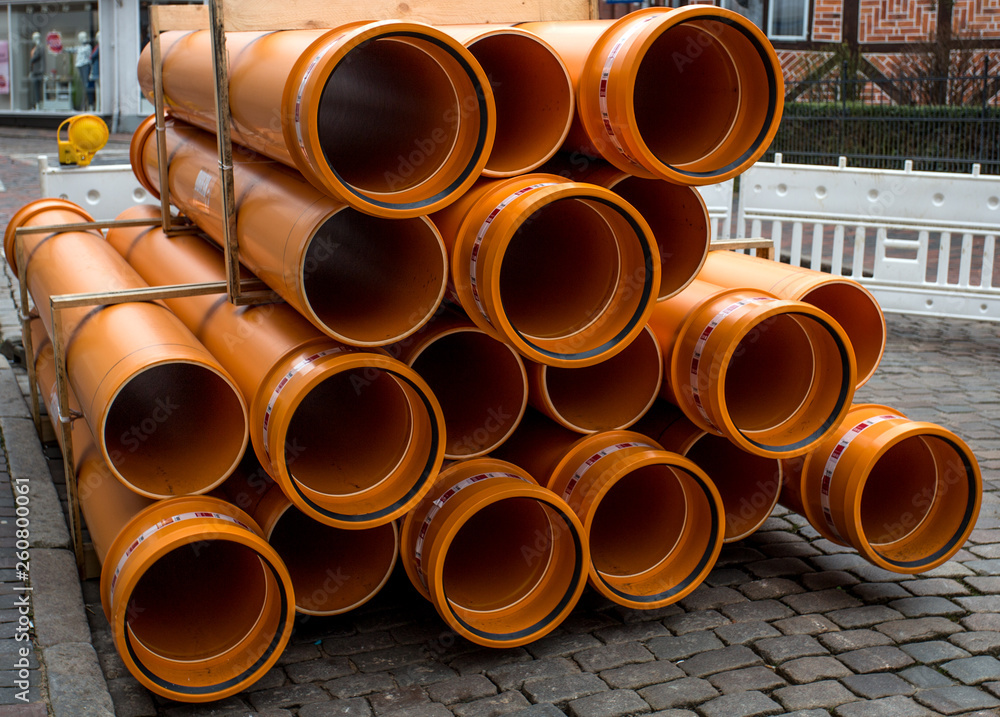 orange PVC pipes stacked in construction site orange PVC pipes stacked in construction site