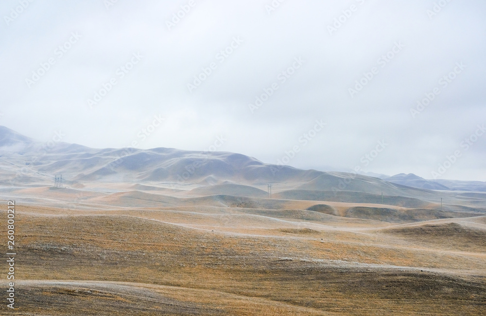 Winter landscape, mountains in the fog, the grass covered with frost