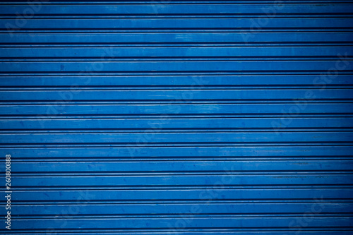 Old blue shuttered roll up metal door.