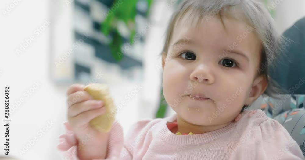 Baby girl attemtping to eat a cookie by herself. Cinematic 4K footage. Real life, not staged. Baby girl attemtping to eat a cookie by herself. Cinematic 4K footage. Real life, not staged.