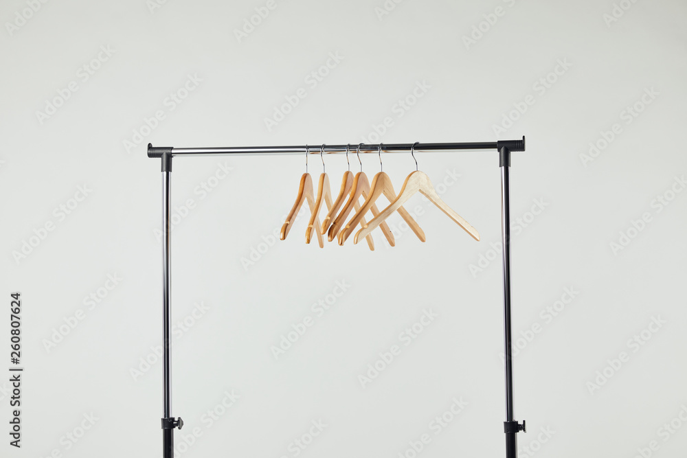 Obraz premium Steel straight rack with wooden hangers isolated on grey