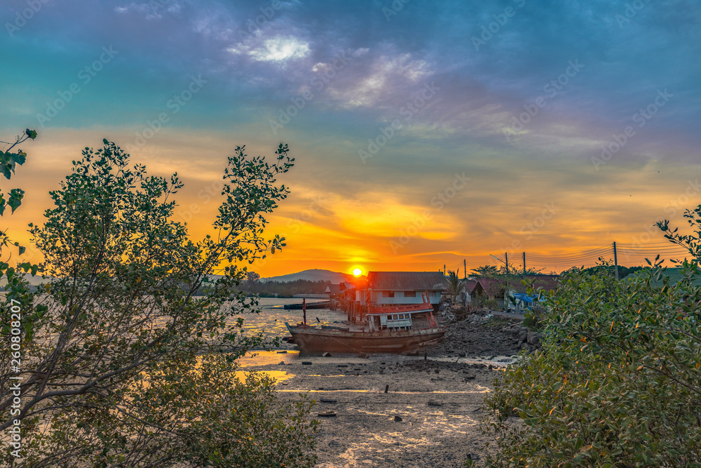 stunning sunset at fishing village in Phuket.during low tide will has a small canal beside fishing village..