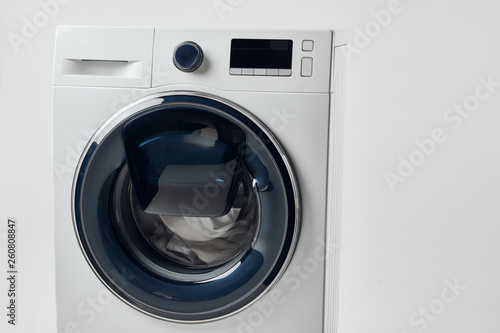 Modern washing machine with black display isolated on grey