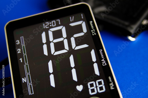 Close up of digital monitor gauge with cuff showing high diastolic and systolic blood pressure photo