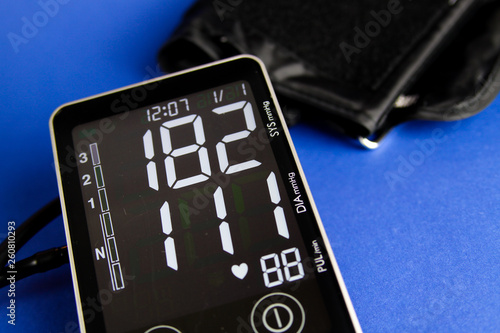 Close up of digital monitor device with cuff showing high diastolic and systolic blood pressure photo