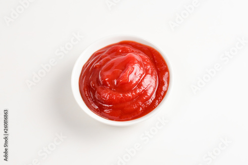 Ketchup in white plate on white background.