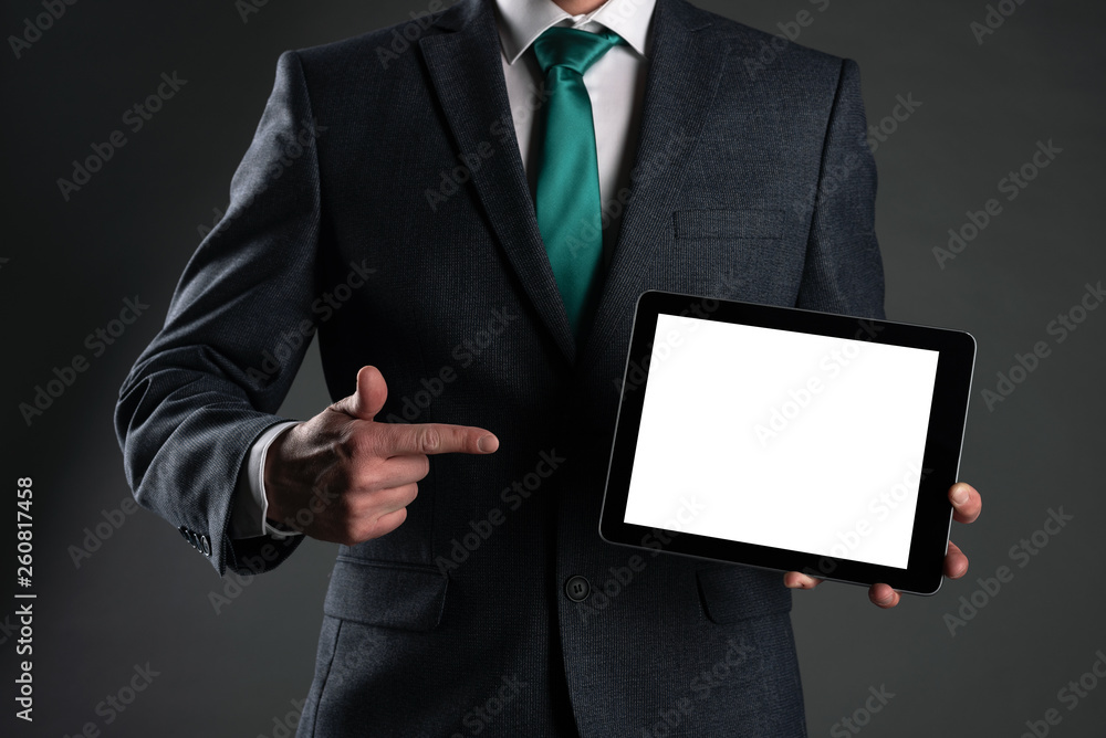 Digital tablet computer with a blank screen in a business man hands on gray background. Special offer mock up. Business proposal template. Contact us phone number background with copy space. Digital tablet computer with a blank screen in a business man hands on gray background. Special offer mock up. Business proposal template. Contact us phone number background with copy space.