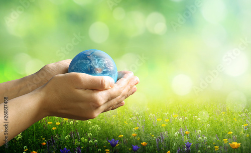  Earth day holiday concept.Close up image of human hands holding  planet earth against green nature background.Environment  concept. photo