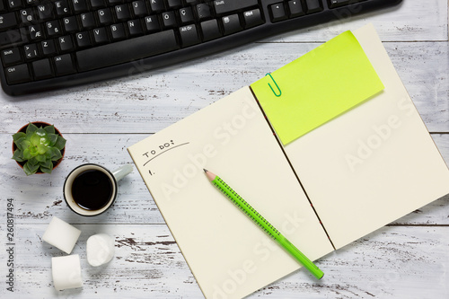 Top view of a workspace with open empty notebook. photo