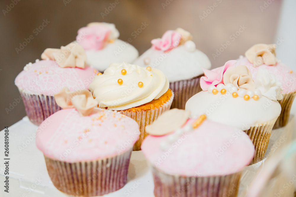 some cupcakes with white and pink cream and golden sparkles