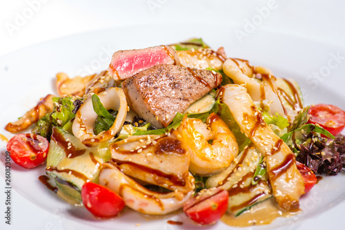 seafood salad with teriyaki sauce in a white plate