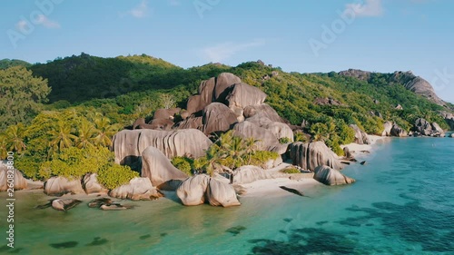 Aerial drone circle 4k footage of the most beautiful Anse Source D'argent beach on La Digue island, Seychelles. Warm sunset light photo