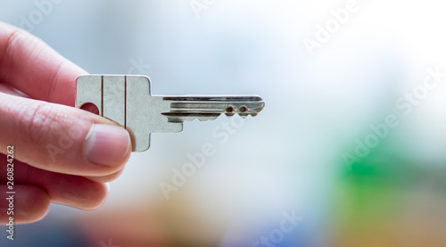 Moving into a new home: Close up of a hand holding a key. Property and real estate. © Patrick Daxenbichler