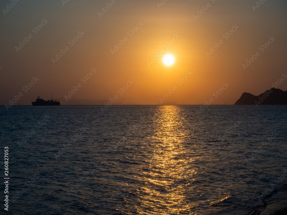 Silhouette of a ferry in the rays of the setting sun with clouds. Koh Phangan Thailand Silhouette of a ferry in the rays of the setting sun with clouds. Koh Phangan Thailand