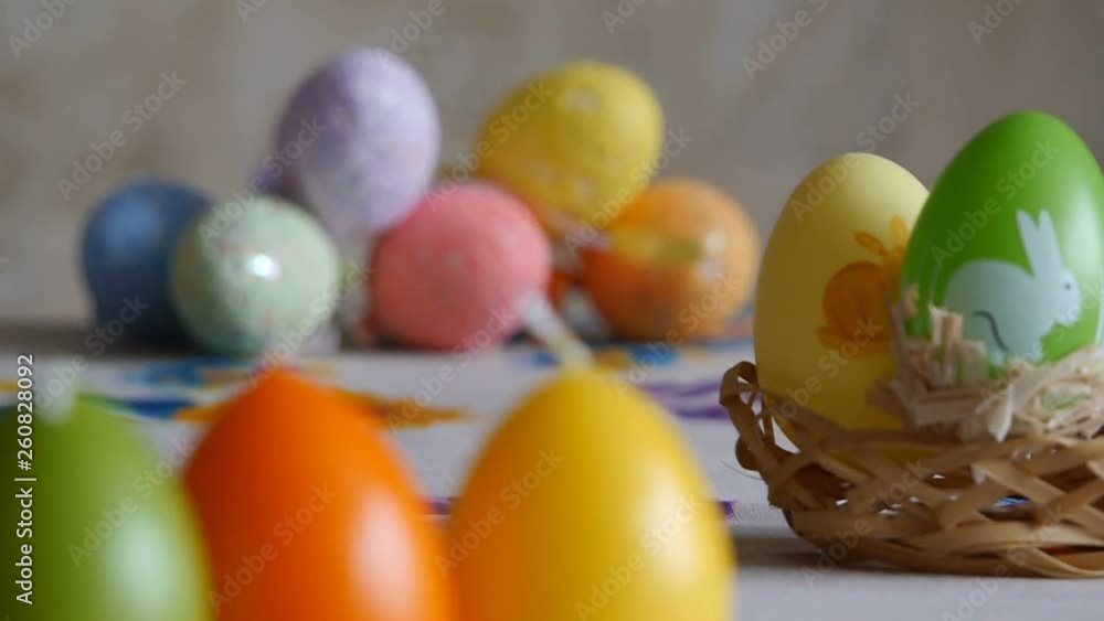 Close-up. Candles made in shape of easter egg. Easter eggs candles and colorful Easter eggs in the background. Refocusing.