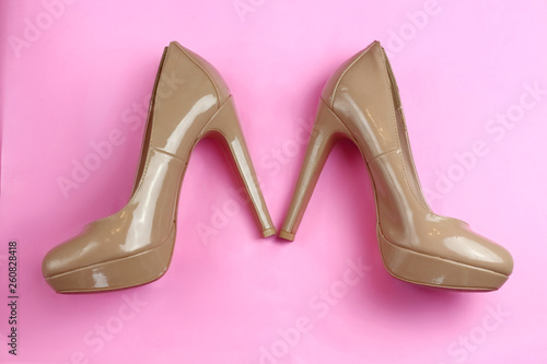Trendy glamour fancy beige nude pink patent glossy pair of elegant high heels shoes on pink background flat lay