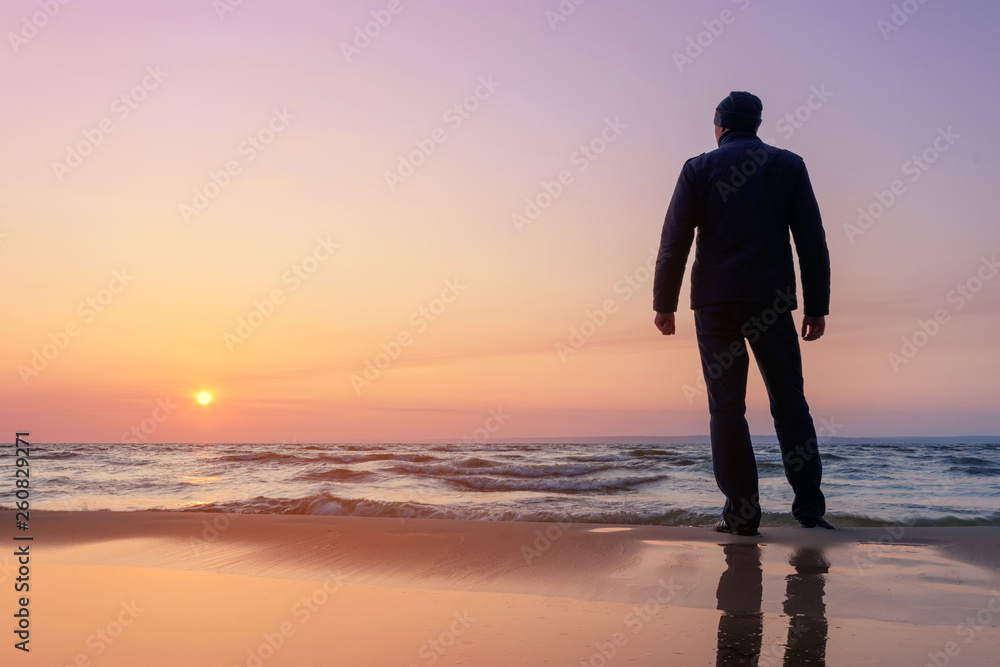 silhouette of a man at dawn / beach wilderness dawn