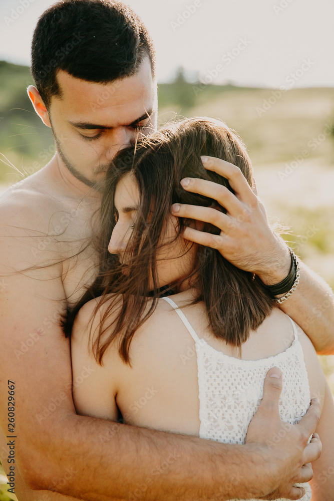 Naklejka premium Sensual outdoor portrait of young stylish fashion couple kissing in autumn field. .