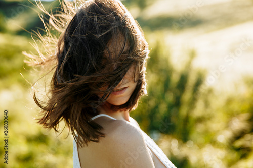 Принти на полотні Happy woman with windy messy hair backlit by sun selective focus colorized image