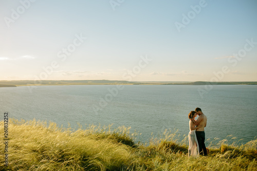 Love, romantic and nature concept - young couple hugging near the lake. Russia