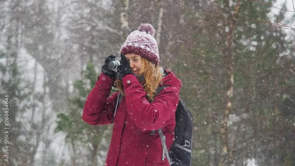 Woman backpacker in a winter hike snow forest trail national par Young girl enjoy snow falling . Happy winter holidays active lifestyle concept. Woman backpacker in a winter hike snow forest trail national par Young girl enjoy snow falling . Happy winter holidays active lifestyle concept.