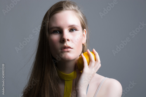 portrait of a girl with lemons on a gray background