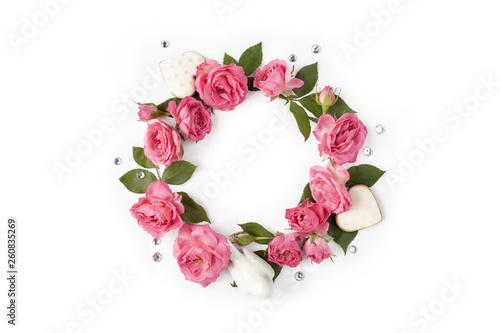 Floral round wreath. Flowers frame made of roses, hearts, leaves and rhinestones isolated on white background.