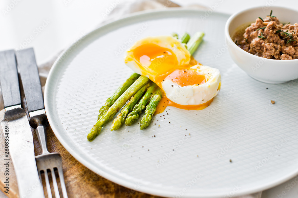 Mini grilled asparagus with egg and tuna. White background, side view.