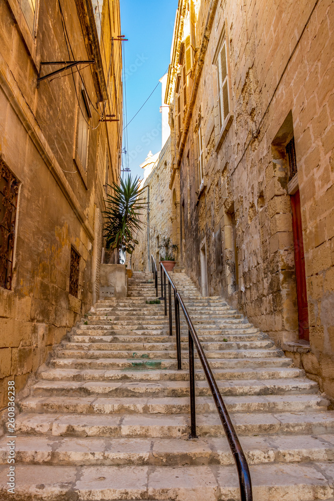 A typical old narrow limestone stairway street at Senglea, Malta