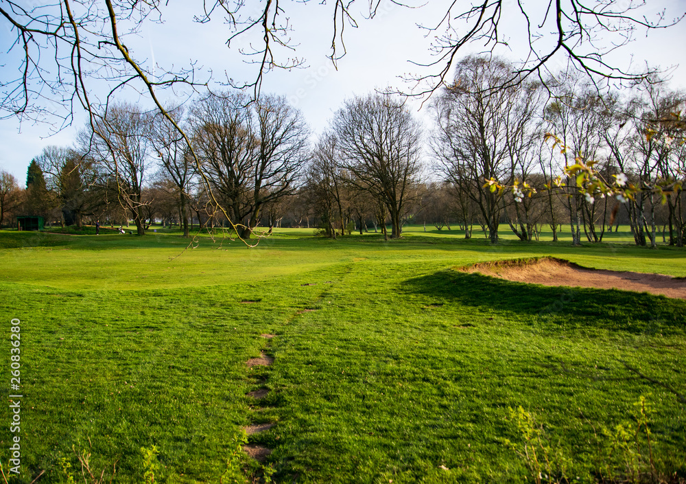 A golf field in the rural England observed from the public area