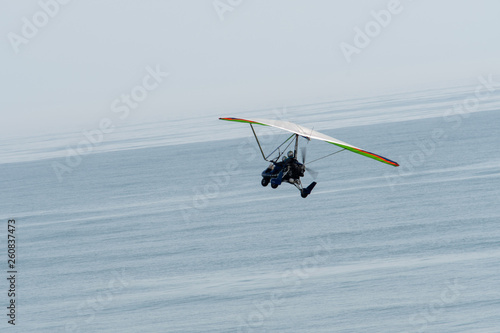 Fototapeta Naklejka Na Ścianę i Meble -  An ultralight trike in flight over the Florida coast.