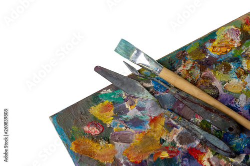 oil paints and paint brushes on a palette isolated on white