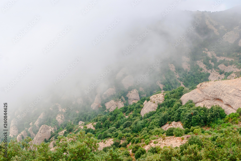 Hazy unusual mountains with green trees and cloudy sky near Montserrat Monastery,Spain Hazy unusual mountains with green trees and cloudy sky near Montserrat Monastery,Spain